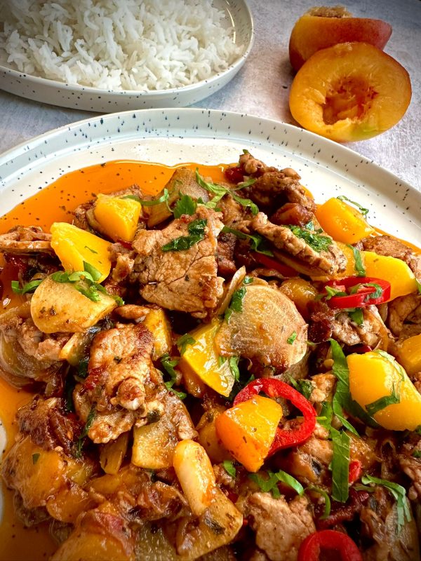 Stir-fried beef with yellow and red peppers, fresh herbs, and a spiced sauce, served with white rice